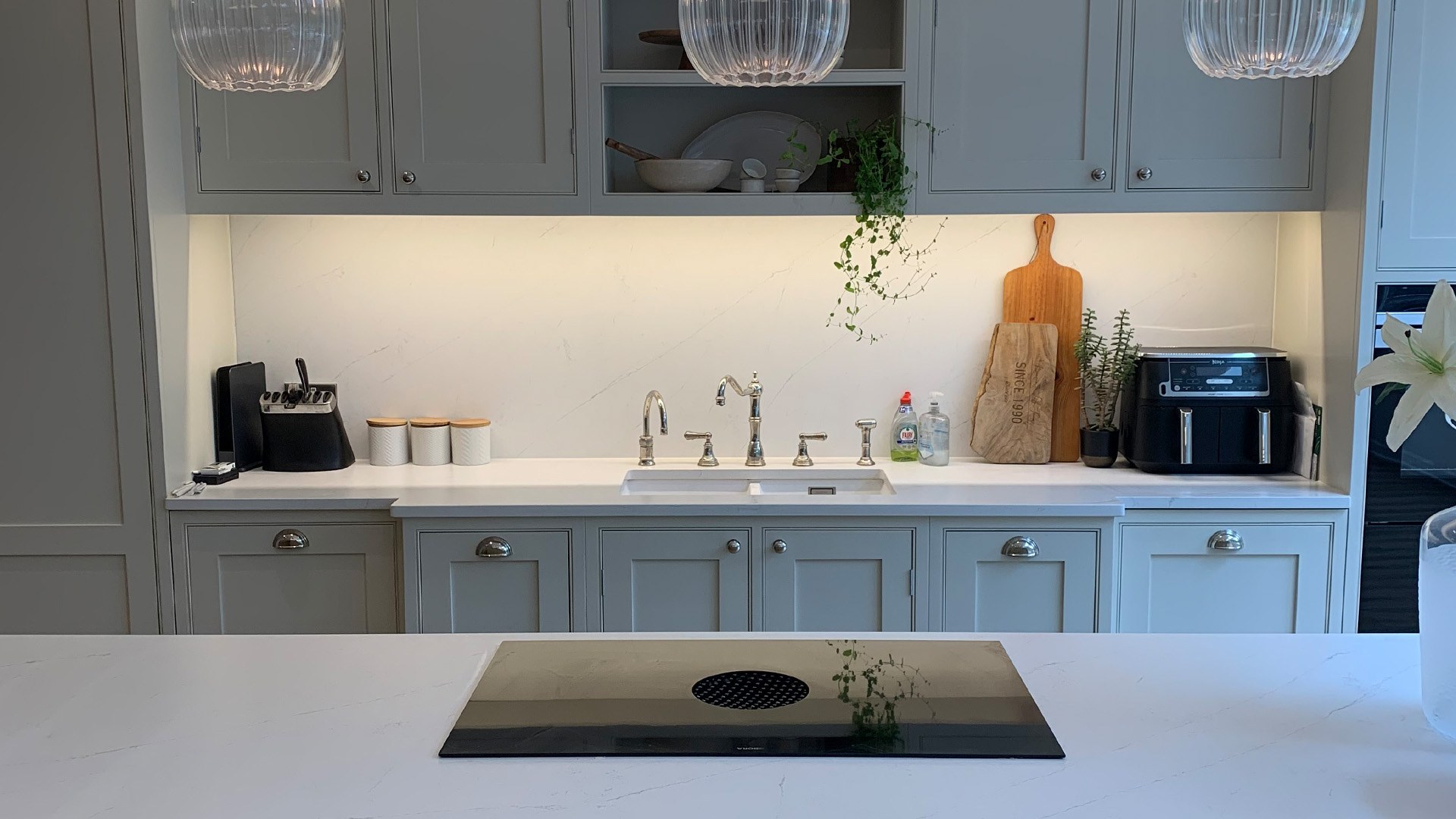 Grey shaker kitchen with white worktop and brushed taps fitted in London